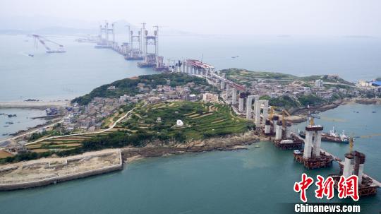 图为,正在建设中的平潭海峡公铁两用大桥 朱戈 摄 平潭海峡公铁两用大桥完成首个航道主塔封顶