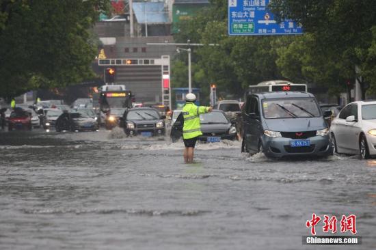 4月22日下午,湖北宜昌突降暴雨,造成市内多路段积水,内涝严重。当地交警、消防紧急出动,确保交通顺畅和民众安全。宜昌市西陵消防中队分组深入内涝区寻找被困人员。截至当日16时30分,消防官兵共疏散50人,救出被困人员6人。图为交警在暴雨中指挥交通。朱华刚 摄 4月自然灾害致全国1471.9万人次受灾 26人死亡