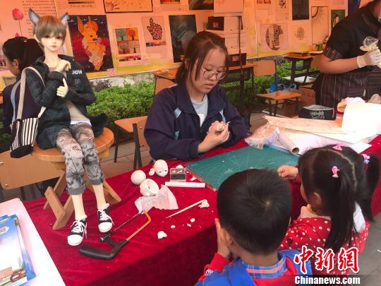 职业教育活动周上职业院校学生展示的手工动漫作品吸引了小朋友观看。 杨静 摄 山西2018年计划投入6.5亿元打造示范性职业院校