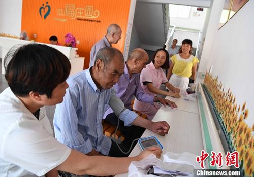 资料图:乡镇卫生院的医护人员为住在敬老院的老人进行体检。记者 张斌 摄 国家卫健委:未来老人照护的主体应是社区和家庭