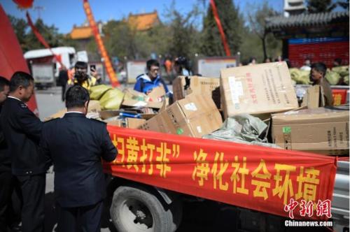 资料图:执法人员查看非法制品。记者 刘文华 摄 一大批新规12月起施行:扫黄打非举报最高奖60万元